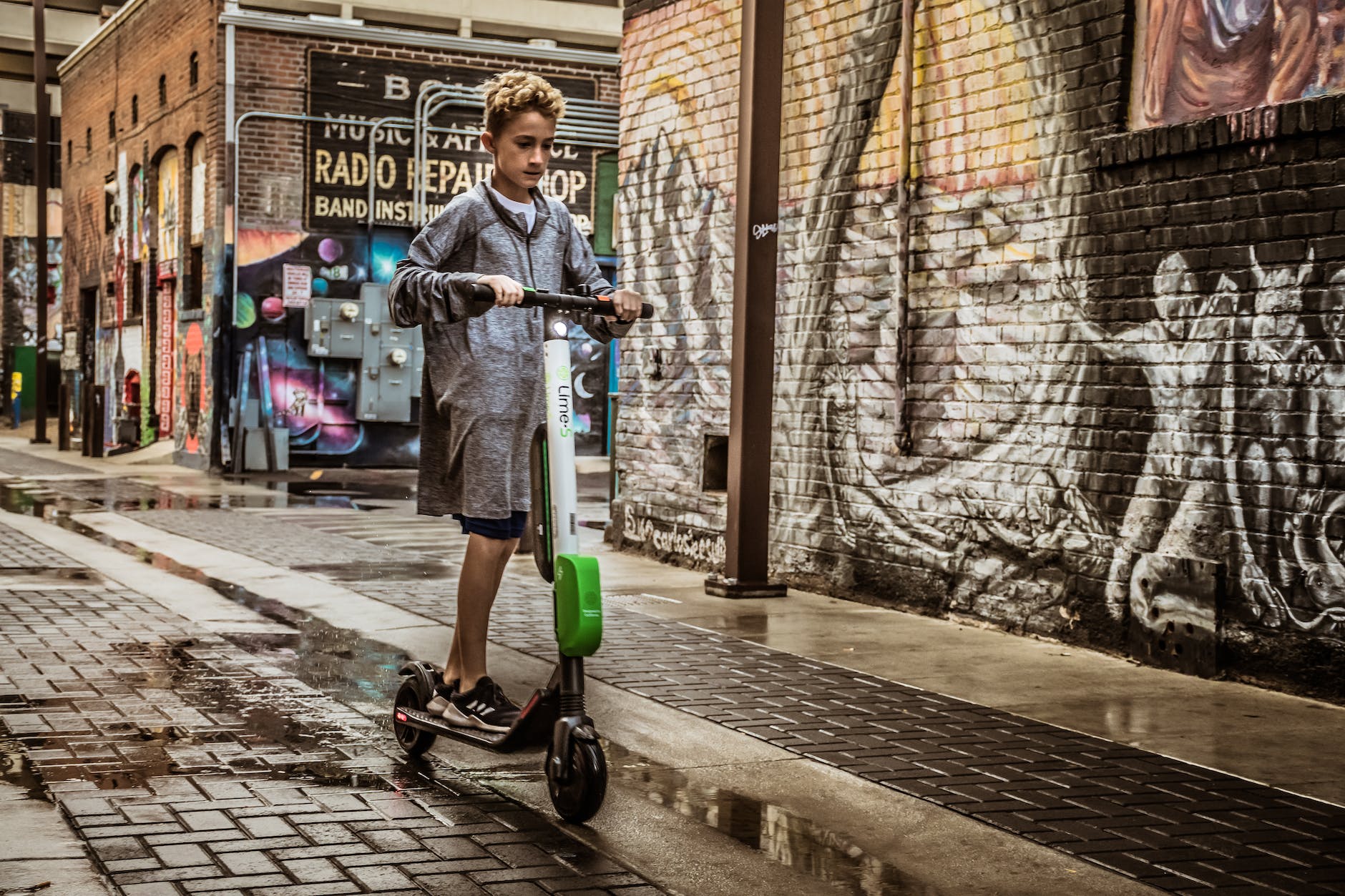 boy standing on black and white kick scooter