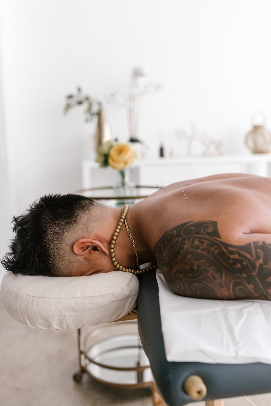 a topless man lying on bed